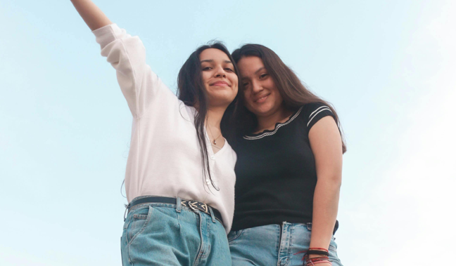 En bild på två unga kvinnor som ser lyckliga ut